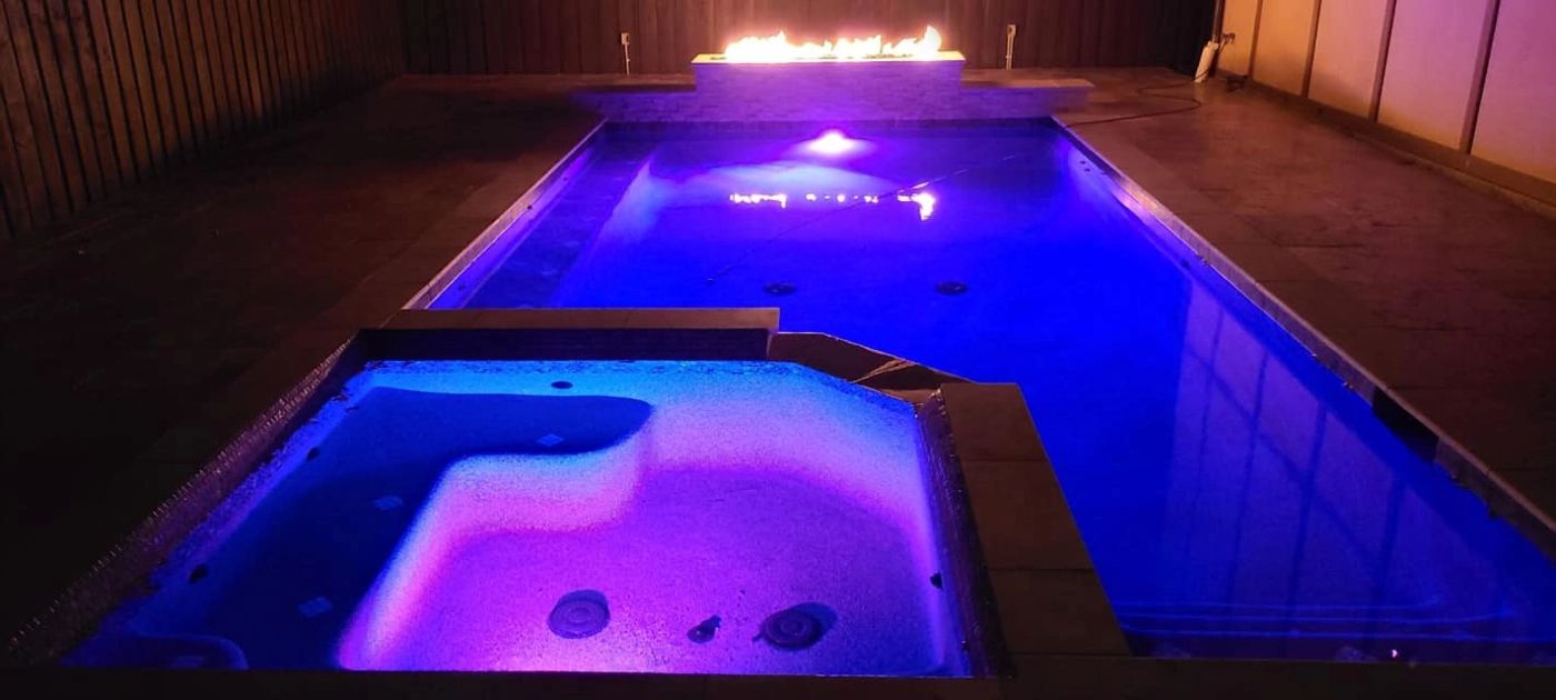 Completed custom pool and spa illuminated in the evening