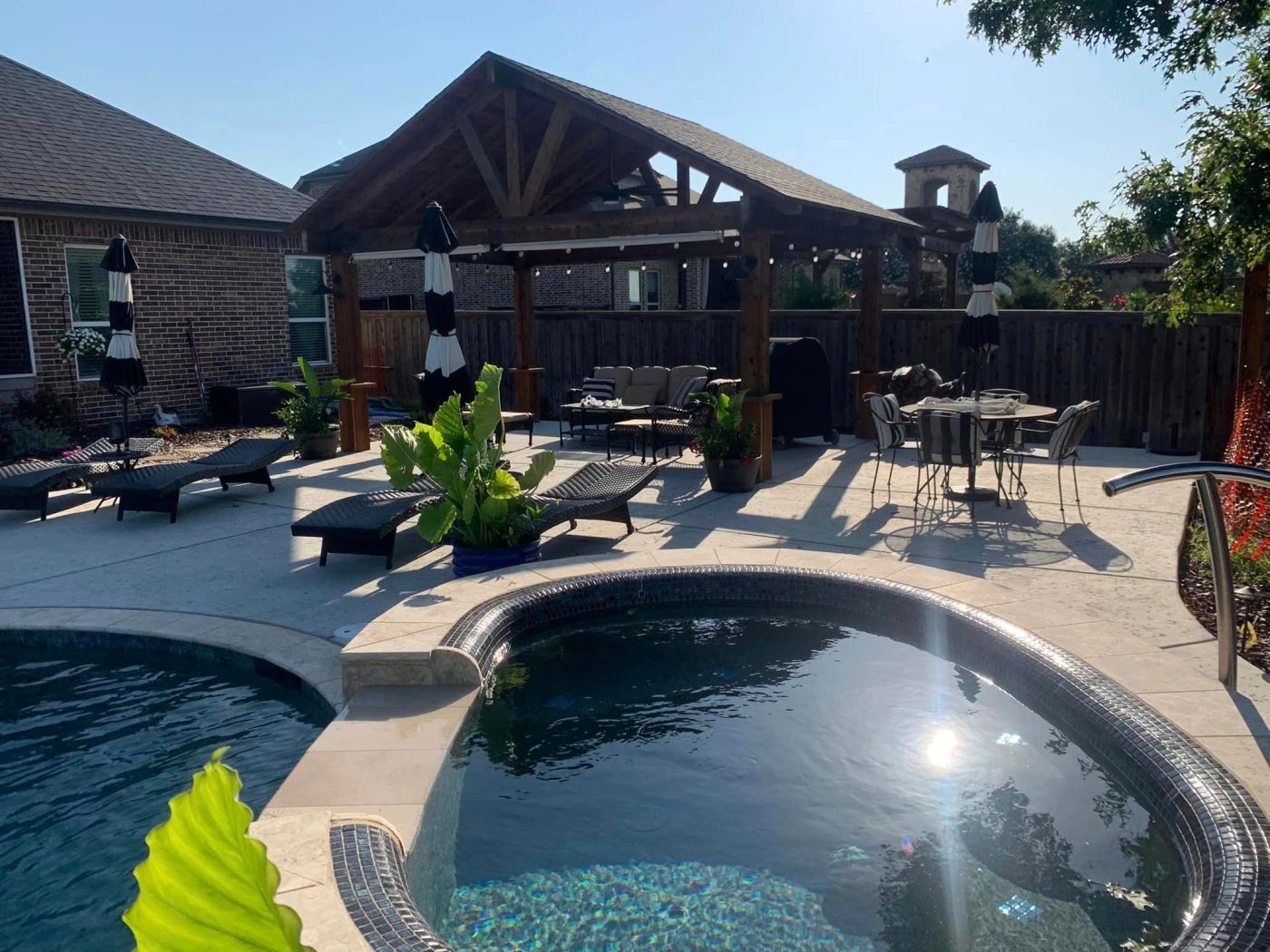 Custom swimming pool and raised spa with patio cover